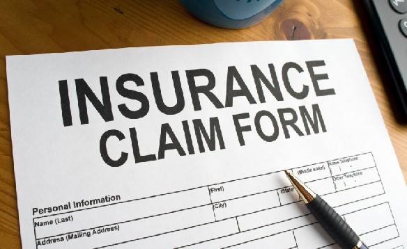 Close-up of an insurance claim form with a pen on top, representing the water damage insurance claims process in Illinois